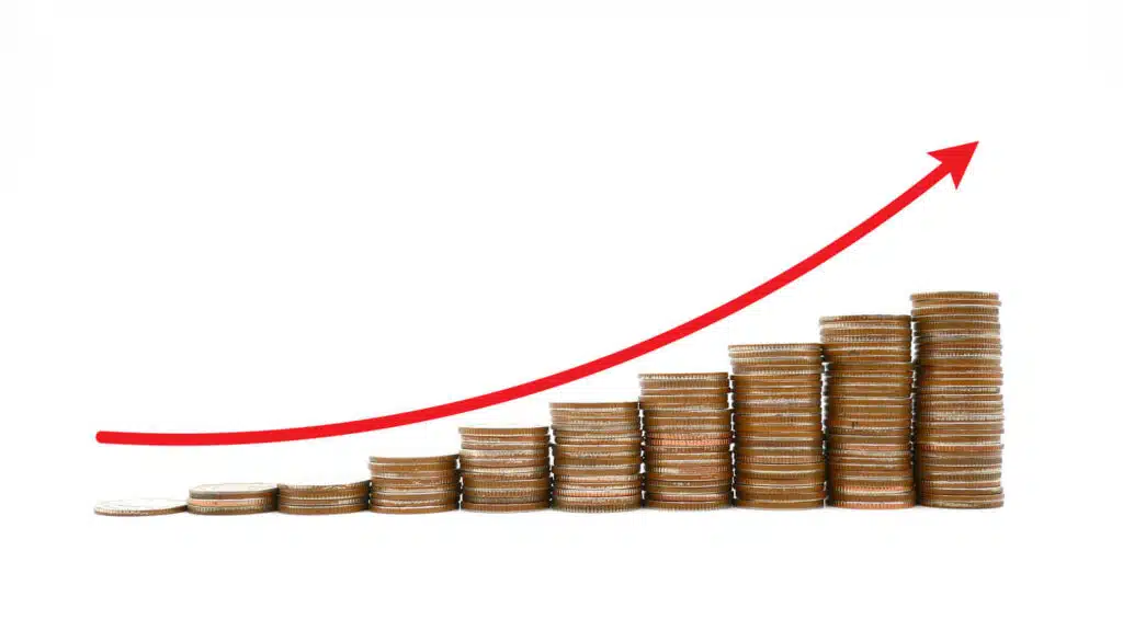 A stack of coins with a red line ascending from left to right to show the idea of growing profits