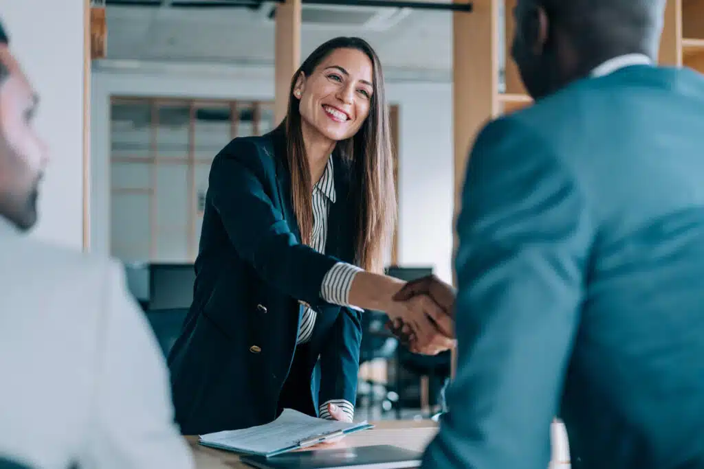 Business people shaking hands in the office after making a deal to adopt a new legal e billing solution.