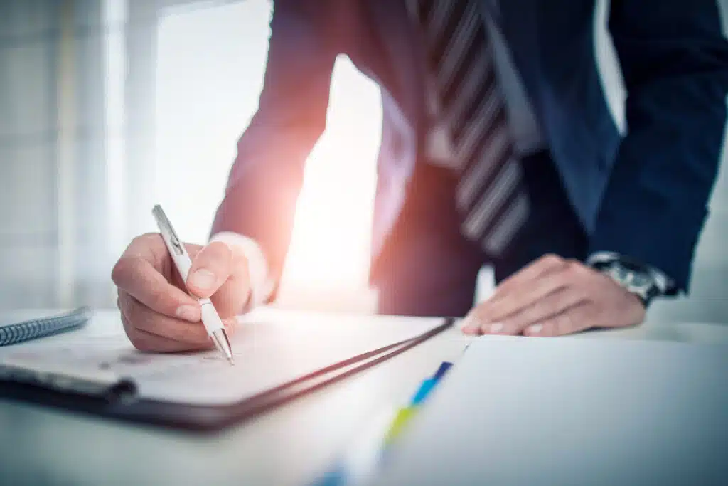 A lawyer manually fills out an invoice in an office setting