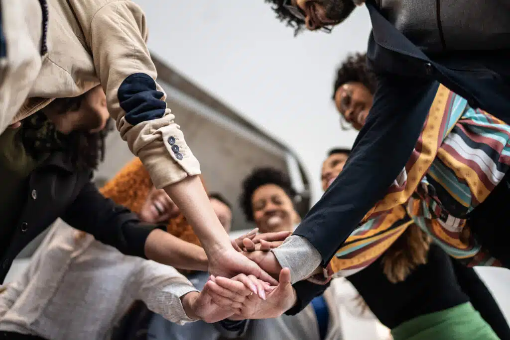 A law firm team breaks a huddle after discussing how to improve their law firm’s culture